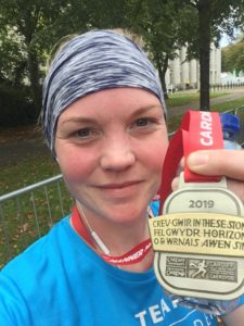 Sandra Johnson holding her Cardiff Half Marathon Medal